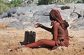 Femme himba assurant une corvée d'eau en Namibie ; Dans la région désertique ou vivent les Himbas, ce sont les femmes qui assurent l'approvisionnement en eau du village (krall) souvent à plusieurs kilomètres des points d'eau ou des rivières.