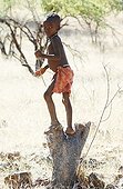 Young himba boy playing as a hunter with a bow in Namibia 