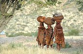 Himba women starting trip in Namibia ; The himbas women go often for long journeys with just the minimum on their heads, a specific freedom of this people.