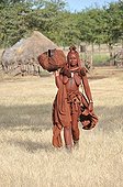 Himba woman starting a trip in Namibia  ; The himbas women go often for long journeys with just the minimum on their heads, a specific freedom of this people.