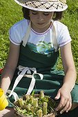 Little girl making an insect shelter in a garden