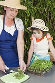 Little girl and her mother gardening on garden terrace