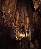 Sedimentary rock - Portugal ; Speleologists exploring a large cave with stalactites, stalagmites, rock columns and rock curtains. Almonda cave. Central Portugal