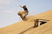 Sand boarding in the dunes of the Namib Desert 