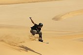 Sand boarding in the dunes of the Namib Desert 