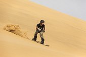 Sand boarding in the dunes of the Namib Desert 