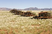 NamibRand Nature Reserve ; Namibia - The chalets of the exclusive Wolwedans dunes lodge in a beautiful setting in the private NamibRand Nature Reserve at the edge of the Namib Desert. In March during the rainy season with green Bushman grass (Stipagrostis sp.)