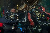 Aquanauts  enter the wet porch - Aquarius Reef Base Florida ; Aquanauts re-filling their tanks in the wet porch; though a direct bypass hose attached to their regulators, divers can connect their empty tank onto an air filling station, while still carrying their tanks on the back.