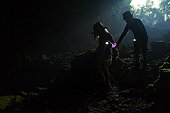Children exploring a cave with flashlights - France