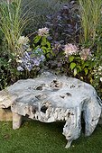 Teak root coffee table in a garden ; Landscaper: Pierre-Alexandre RISSER
