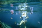 Female swimer surronded by Jellyfish Palagia noctiluca