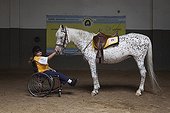 Femme paraplégique et cheval dans un centre d'équithérapie ; Roxane 38 ans handicapée et en fauteuil depuis la naissance aime monter depuis 14 ans qu’elle se rend au centre. Elle fait du trot et des exercices d’équilibres qui lui permettent en plus du plaisir d’être au contact du cheval de développer ses muscles.<br>Equithérapie en partenariat avec l'Association AAAEPAD et Ariel Pagani équithérapeute<br>Asociacion Argentina de Actividades Ecuestre para Discapacitados<br>