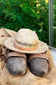 Hat and garden clogs on hessian