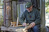 Man working on a piece of wood to do a tool - Basque Country ; Pantiere Lanne,<br>used to fold the pigeon flights