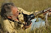 Man photographing an Indian Cobra in the grass ; Photographer: Daniel Heuclin