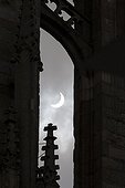 Partial Solar Eclipse and Cathedral - Brittany France ; A cloud of sail reduces sunlight and transforms the dazzling sun disk in a growing, albeit very bright, but bearable. Details of the architecture of the cathedral Saint Corentin Quimper adorn the foreground.