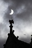 Partial Solar Eclipse and Cathedral - Brittany France ; A cloud of sail reduces sunlight and transforms the dazzling sun disk in a growing, albeit very bright, but bearable. Details of the architecture of the cathedral Saint Corentin Quimper adorn the foreground. 