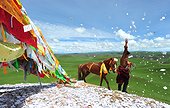 Rider praying before the race when Lapsté - Tibet China  ; Equestrian Festival Lapste <br>Before racing, the riders and their horses are praying gods by turning around a stupa and throwing sacred papers in the air.