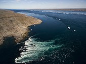 Aerial view of iceberg grounded in shallow rapids during tidal rip in Wager Bay on summer morning, Ukkusiksalik National Park, Nunavut Territory, Canada