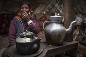 Woman and boiler inside a Yack wool tent, Surroundings of Korzok, Leh, Ladakh, Himalayas, India