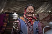 Woman with prayer wheel inside a Yack wool tent, Surroundings of Korzok, Leh, Ladakh, Himalayas, India