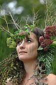 Young woman with crown flowers on her head - living in harmony with nature - reconnecting with nature