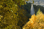La « demoiselle coiffée », une cheminée de fée qui se dresse au dessus de la forêt de mélèzes dans le Queyras, Hautes-Alpes. Vue depuis le bois d’érable du versant opposé.