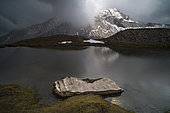 L'orage du soir arrive au lac de l'Eychassier face à la Taillante dans le Queyras, Hautes-Alpes. Mois de septembre, la première neige est déjà arrivée.