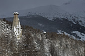 La "demoiselle coiffée", la cheminée de fée au dessus de Château Ville-Vieille dans le Queyras, Hautes-Alpes. Éclaircie pendant le mauvais temps, neige fraiche de janvier.