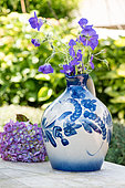 Perennial geranium in a jug on a garden table, summer, Pas de Calais, France