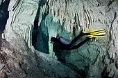 scuba diver (model released) swimming through caverns and tunnels accessed from the surface via a cenote in the jungle. This underground river system spiders across the Yucatan Peninsula, an eerie realm known by the local Maya people as Xilbalba which translates into Place of Fear