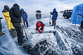 Cutting a hole in the ice before a dive - Lake Baikal, Siberia, Russia
