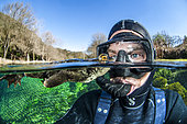 Selfie with a Common toad (Bufo bufo) swimming at the surface, Buèges spring, Occitania, France
