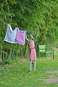 Wooden statue of someone hanging out the washing in the St Adrian Garden, Hérault, France