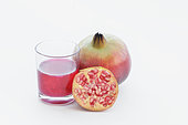 Pomegranate juice, half and full pomegranate on a white background