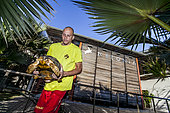 Thomas, a nurse at the KELONIA health care centre, releasing a tortoise in her pen in the public part of the centre, Reunion Island