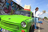 Urban Beekeeping - Erica Mayr, 37 years old, posing with a Trabant, a hive and a smoker close to what is left of the Berlin Wall near Warschauer Strabe. Germany