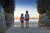 Little girls admiring the sunset on a beach in northern France in summer