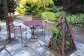 "The Purple Garden", paved terrace with iron furniture and pyramid where a Rose campion (Lychnis coronaria) grows, Jardins du Pays d'Auge, Cambremer, Calvados, Normandie, France