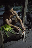 Man performing a ritual after killing a wild pig, Pulau Siberut, Sumatra, Indonesia