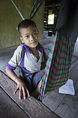 Child preparing for the siesta in his hammock, Pulau Siberut, Sumatra, Indonesia