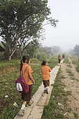 Children going to primary school on the main road to the village of Madobag, Pulau Siberut, Sumatra, Indonesia