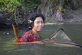 Woman fishing with landing net, Pulau Siberut, Sumatra, Indonesia