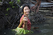 Woman fishing with a landing net, Pulau Siberut, Sumatra, Indonesia