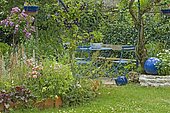 Garden furniture: table, chair. Spring mass: Stem rose, Corallbell(Heuchera sp). Mainly blue garden. France