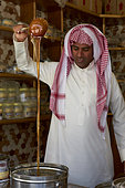 Saudi merchant showing his honey, Taif souq, Saudi Arabia