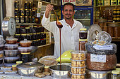 Yemeni merchant showing his honey, Taif souq, Saudi Arabia