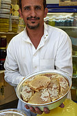 Yemeni merchant showing his honey, Taif souq, Saudi Arabia