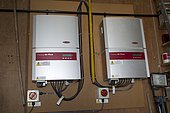 Two wall mounted Fronius IG inverters converting DC electricity from PV to AC UK