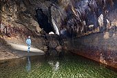 Speleologist in front of a beautiful fault mirror in a cave. UNESCO label "Géoparc", Bauges Regional Nature Park, Savoie, Alps, France
